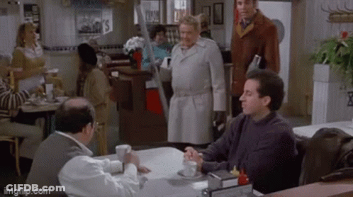 A Group Of Men Are Sitting At A Table In A Diner GIF