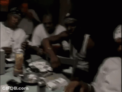 A Group Of Men Are Sitting At A Table In A Restaurant . GIF