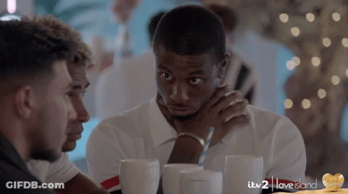 A Group Of Men Are Sitting At A Table With Itv 2 Love Island Written In The Corner GIF