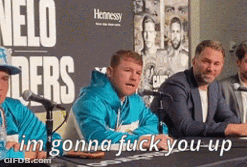 A Group Of Men Are Sitting At A Table With Microphones In Front Of A Sign That Says Nelo Fighters GIF
