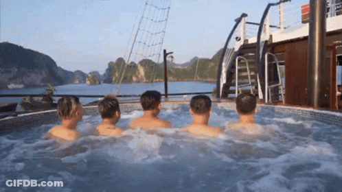 A Group Of Men Are Sitting In A Hot Tub On The Deck Of A Boat GIF