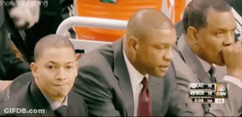A Group Of Men Are Sitting In A Stadium Watching A Basketball Game GIF
