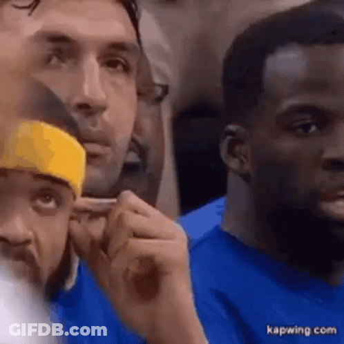 A Group Of Men Are Sitting In A Stadium Watching A Game . GIF