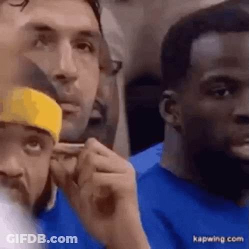 A Group Of Men Are Sitting In A Stadium Watching A Game . GIF