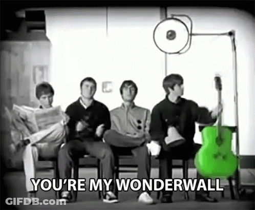 A Group Of Men Are Sitting In Chairs With A Green Guitar And The Words You 'Re My Wonderwall Above Them . GIF