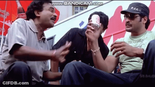 A Group Of Men Are Sitting In Front Of A Coca Cola Advertisement . GIF
