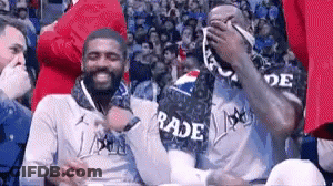 A Group Of Men Are Sitting In The Stands At A Basketball Game Wearing Rade Jerseys . GIF