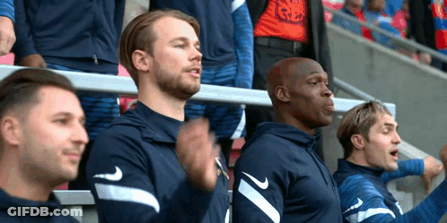 A Group Of Men Are Sitting In The Stands At A Soccer Game Wearing Nike Shirts . GIF
