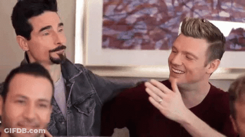 A Group Of Men Are Sitting On A Couch And Laughing Together . GIF