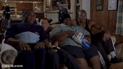 A Group Of Men Are Sitting On A Couch With One Holding A Bag Of Fritos GIF