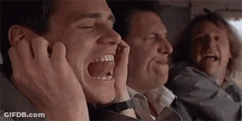 A Group Of Men Are Sitting On A Plane Laughing And Covering Their Ears With Their Hands . GIF