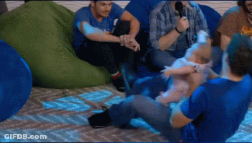 A Group Of Men Are Sitting On Bean Bag Chairs And One Of Them Is Holding A Baby . GIF
