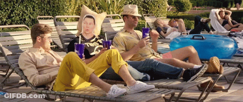 A Group Of Men Are Sitting On Lounge Chairs Near A Pool GIF