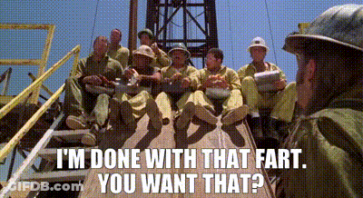 A Group Of Men Are Sitting On Top Of A Wooden Platform And A Man Is Standing In The Background . GIF