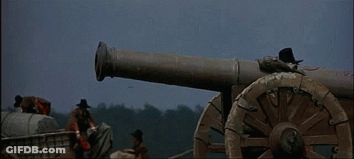 A Group Of Men Are Standing Around A Cannon That Is Firing GIF