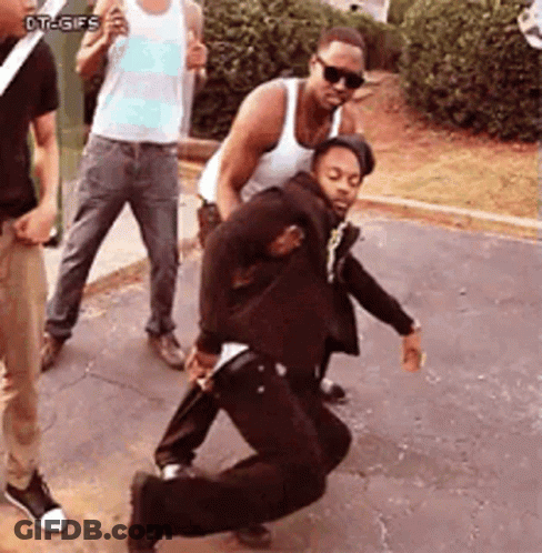 A Group Of Men Are Standing Around A Man In A Suit Who Is Dancing GIF