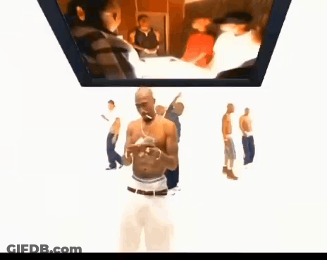 A Group Of Men Are Standing Around A Man Smoking A Cigarette In Front Of A Screen . GIF