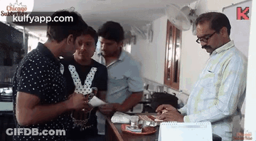 Men Standing Around Table Talking In Restaurant GIF