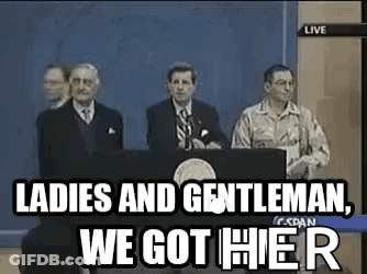 A Group Of Men Are Standing Behind A Podium Giving A Speech . GIF