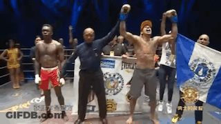 A Group Of Men Are Standing In A Boxing Ring And One Of Them Is Holding A Flag GIF