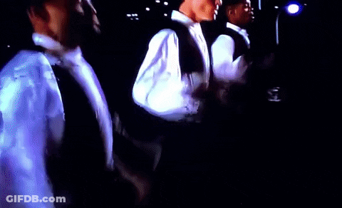 A Group Of Men Are Standing In A Dark Room With A Flashlight GIF
