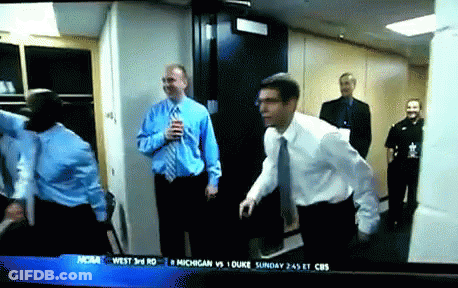 A Group Of Men Are Standing In A Hallway With A Cbs News Headline On The Screen GIF