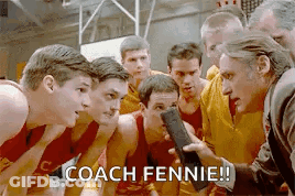 A Group Of Men Are Standing In A Huddle With A Man Holding A Microphone . GIF