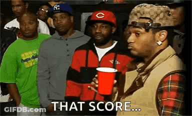 A Group Of Men Are Standing In A Line And One Of Them Is Holding A Red Cup And Says `` That Score ... '' . GIF