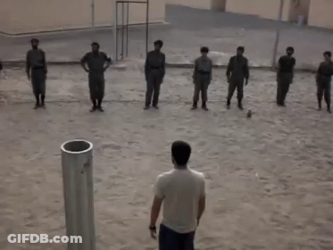 A Group Of Men Are Standing In A Line With Their Hands In The Air GIF