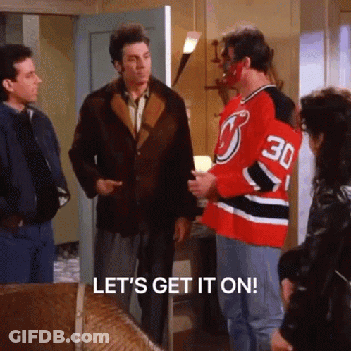 A Group Of Men Are Standing In A Living Room Talking To Each Other And One Of Them Is Wearing A Hockey Jersey . GIF