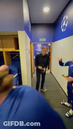 A Group Of Men Are Standing In A Locker Room With A Sign On The Wall That Says Champions League GIF