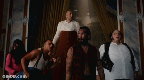 A Group Of Men Are Standing In A Room And One Of Them Has A Tattoo On His Arm GIF