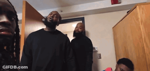 A Group Of Men Are Standing In A Room And One Of Them Has Dreadlocks GIF