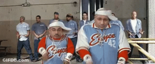 A Group Of Men Are Standing In A Room And One Of Them Is Wearing A Jacket That Says Stance 42 GIF