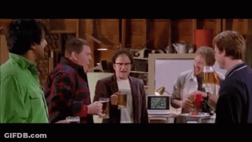 A Group Of Men Are Standing In A Room Holding Beer Mugs . GIF