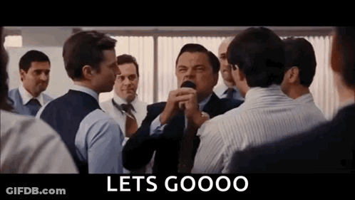 A Group Of Men Are Standing In A Room Talking To Each Other And A Sign That Says Lets Goooo . GIF