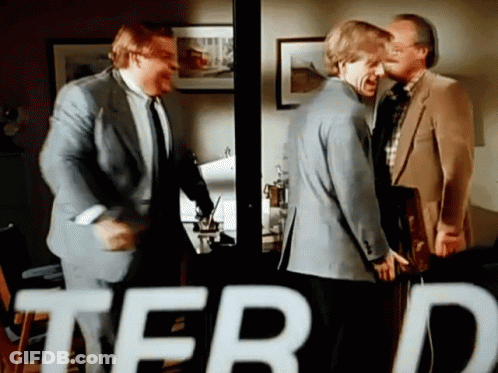 A Group Of Men Are Standing In A Room With The Word Terd In The Corner GIF