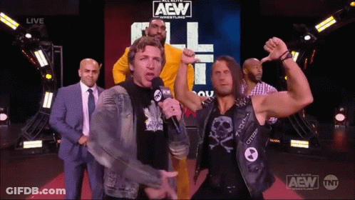 A Group Of Men Are Standing In Front Of A Aew Sign GIF