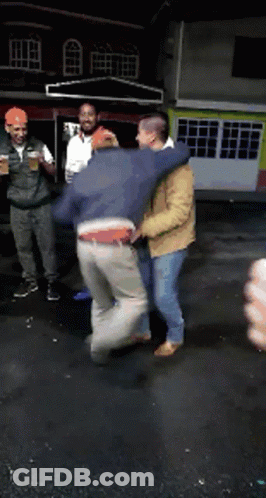 A Group Of Men Are Standing In Front Of A Building Holding Drinks GIF