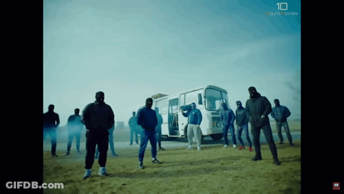 A Group Of Men Are Standing In Front Of A Bus With The Number 10 On The Bottom Right GIF