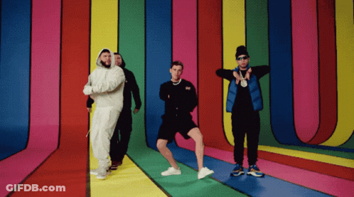 A Group Of Men Are Standing In Front Of A Colorful Wall GIF