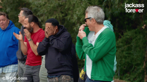 A Group Of Men Are Standing In Front Of A Jackass Forever Sign GIF