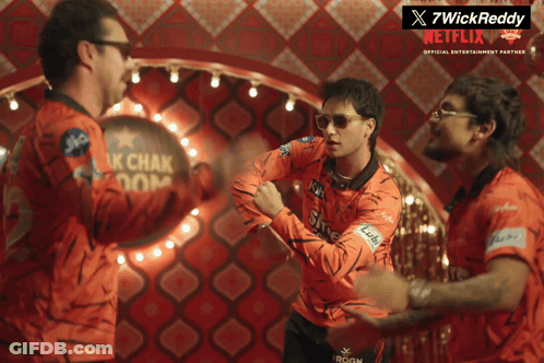 A Group Of Men Are Standing In Front Of A Netflix Sign GIF