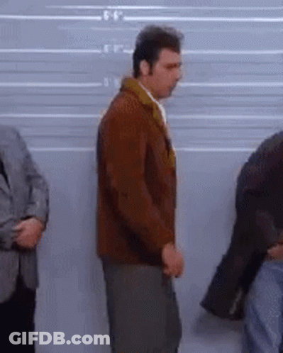 A Group Of Men Are Standing In Front Of A Police Line Up . GIF