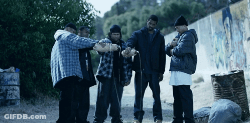 A Group Of Men Are Standing In Front Of A Trash Can That Says Warning On It GIF