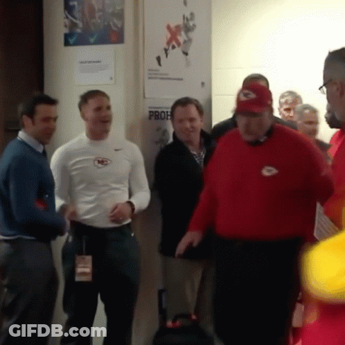 A Group Of Men Are Standing In Front Of A Wall That Has A Prof Sign On It GIF
