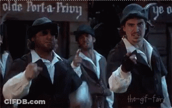 A Group Of Men Are Standing In Front Of An Olde Port-A-Privy Sign . GIF