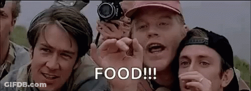 A Group Of Men Are Standing Next To Each Other And One Of Them Is Holding A Camera And Saying Food . GIF