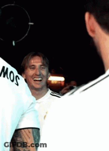 A Group Of Men Are Standing Next To Each Other In A Dark Room And Smiling . GIF