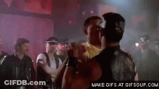 A Group Of Men Are Standing Next To Each Other In A Dark Room . GIF